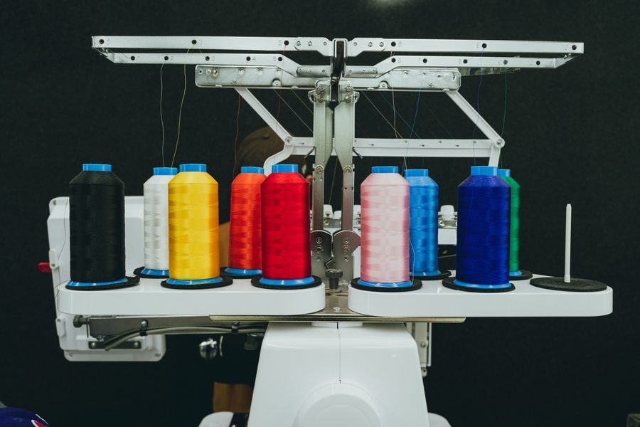 Colourful thread cones loaded on an embroidery machine