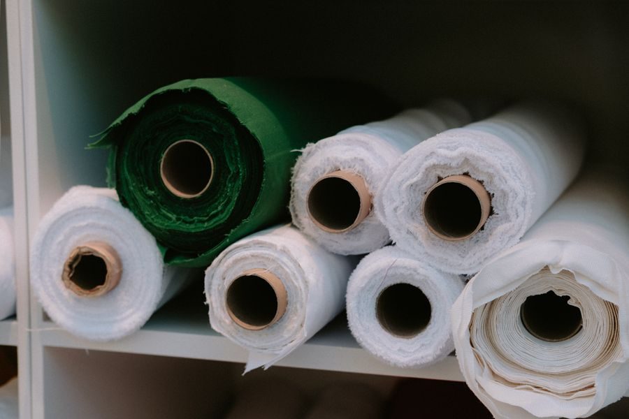 Rolls of white and green fabric on a shelf