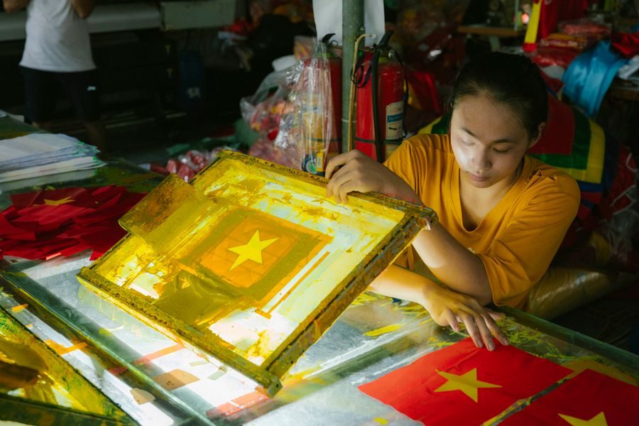 Worker screen printing a design onto fabric